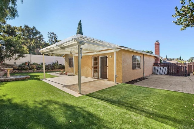 back of property with a pergola, a patio area, and a yard