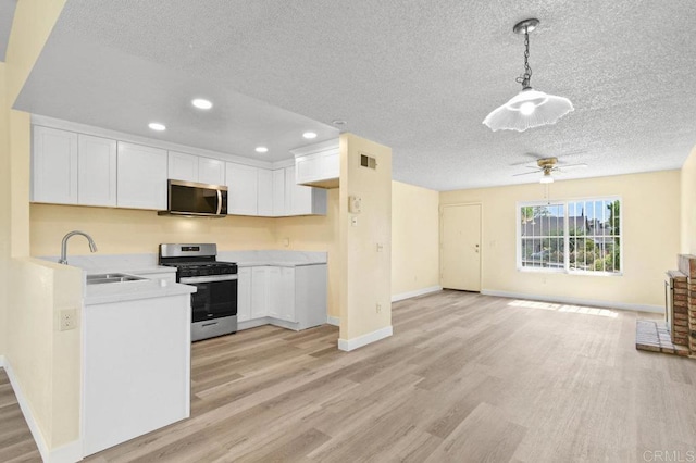 1403 Goff Ct, San Diego, CA 92114 - kitchen with appliances with stainless steel finishes, a sink, light wood-style floors, a textured ceiling, and light countertops