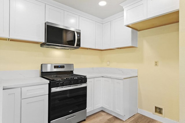 1403 Goff Ct, San Diego, CA 92114 - kitchen featuring appliances with stainless steel finishes, light wood-style flooring, light stone counters, white cabinets, and baseboards