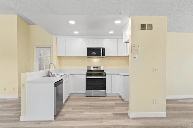 1403 Goff Ct, San Diego, CA 92114 - kitchen with a sink, appliances with stainless steel finishes, light wood-style flooring, a peninsula, and white cabinets