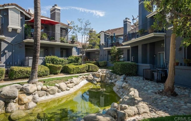 view of property's community with a small pond