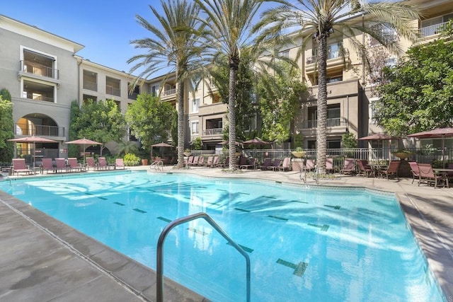 view of swimming pool featuring a patio area and fence