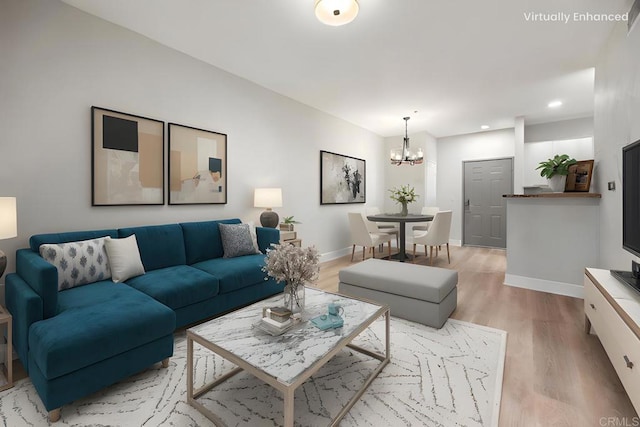 living area with an inviting chandelier, light wood-style flooring, baseboards, and recessed lighting