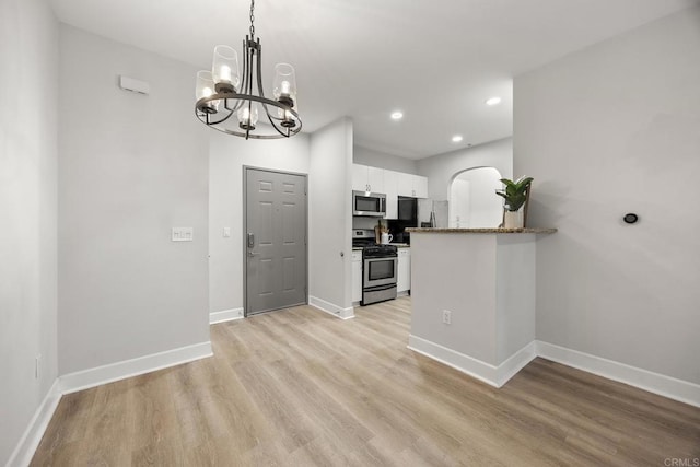 kitchen featuring baseboards, white cabinets, appliances with stainless steel finishes, light wood-type flooring, and recessed lighting