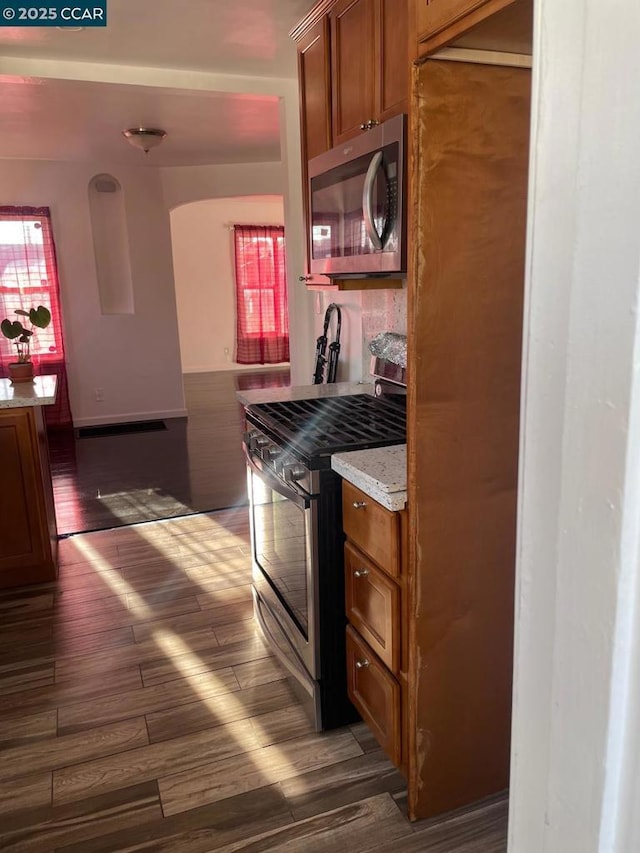 kitchen with appliances with stainless steel finishes and dark hardwood / wood-style floors