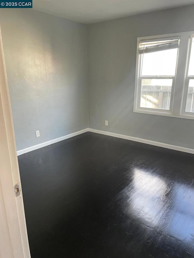 empty room with dark hardwood / wood-style flooring