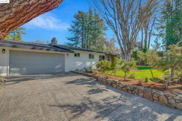 ranch-style house featuring a front lawn and a garage