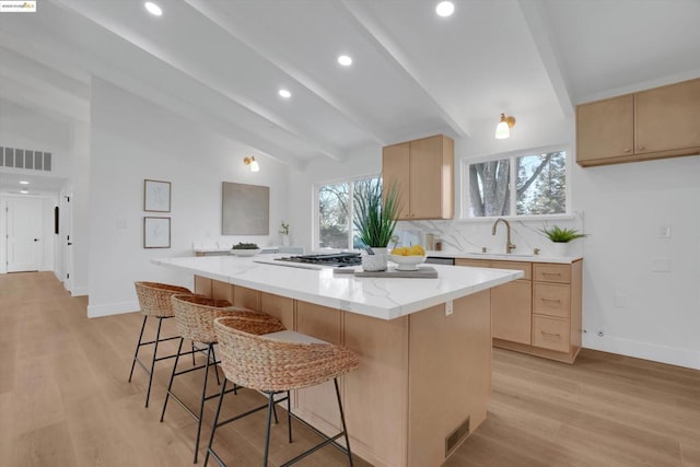 kitchen featuring vaulted ceiling with beams, light hardwood / wood-style flooring, a center island, and sink