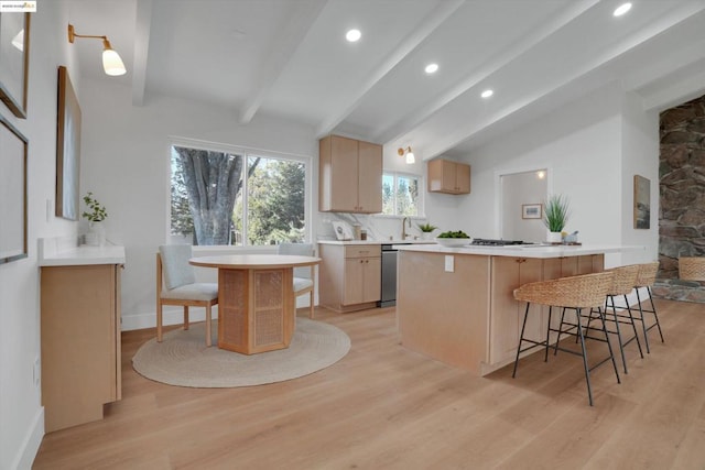 kitchen featuring a breakfast bar area, kitchen peninsula, light brown cabinets, and light hardwood / wood-style flooring