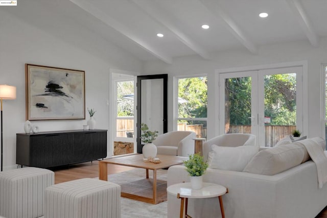 living room with light wood-type flooring, french doors, and lofted ceiling with beams