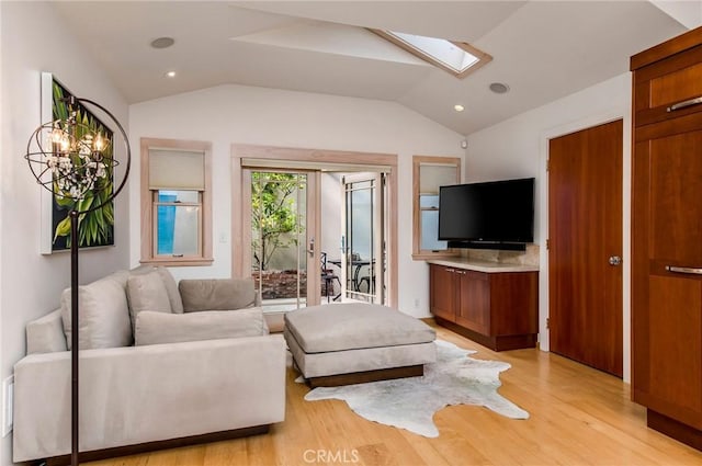 living room featuring light wood-type flooring, lofted ceiling with skylight, and french doors