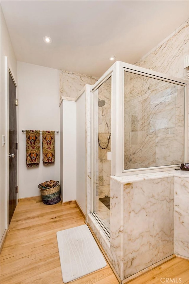 bathroom with walk in shower and hardwood / wood-style floors