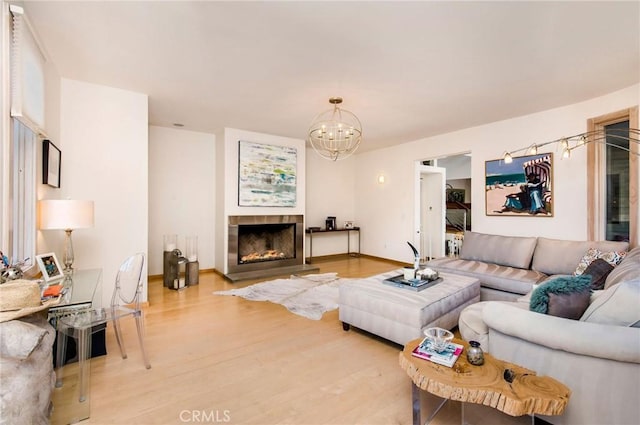 living room featuring a chandelier, a fireplace, and hardwood / wood-style floors