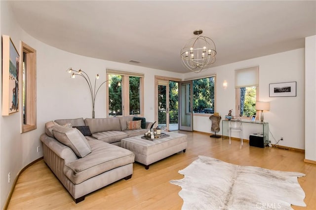 living room with a chandelier and light hardwood / wood-style floors