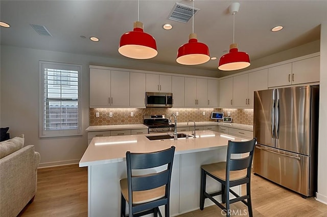 kitchen featuring hanging light fixtures, stainless steel appliances, and white cabinetry