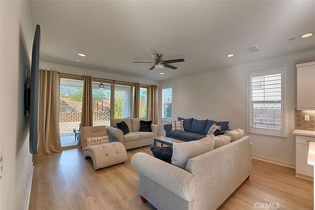 living room featuring ceiling fan, light hardwood / wood-style flooring, and a healthy amount of sunlight