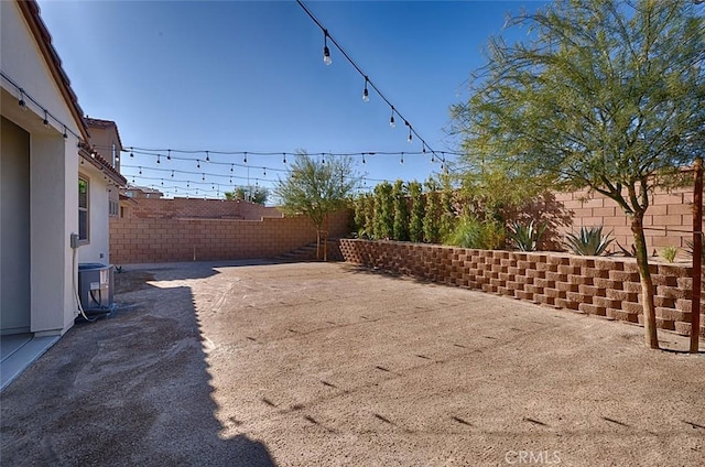 view of yard featuring central AC and a patio