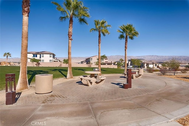 surrounding community with a lawn and a mountain view