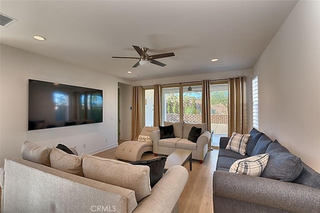 living room with ceiling fan and light hardwood / wood-style flooring