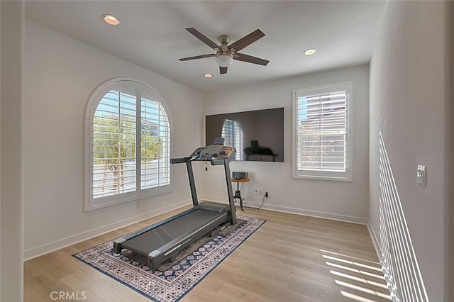 exercise area featuring light wood-type flooring and ceiling fan