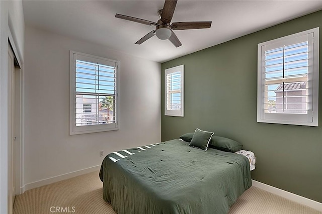 carpeted bedroom featuring ceiling fan and a closet