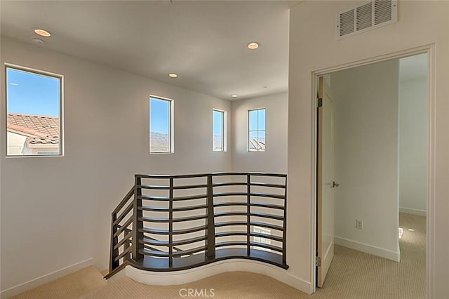 hall featuring light colored carpet