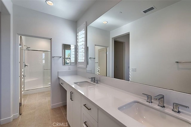 bathroom featuring an enclosed shower, vanity, tile patterned flooring, and toilet