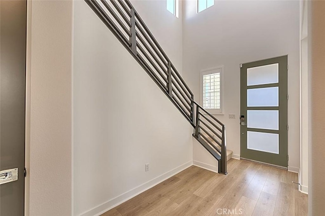 entryway with a high ceiling and light hardwood / wood-style flooring