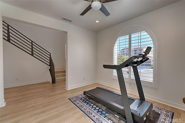 exercise area with ceiling fan and light hardwood / wood-style floors