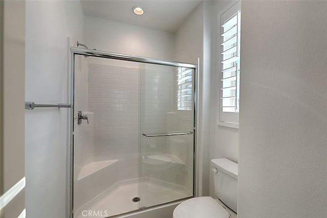 bathroom with an enclosed shower and toilet