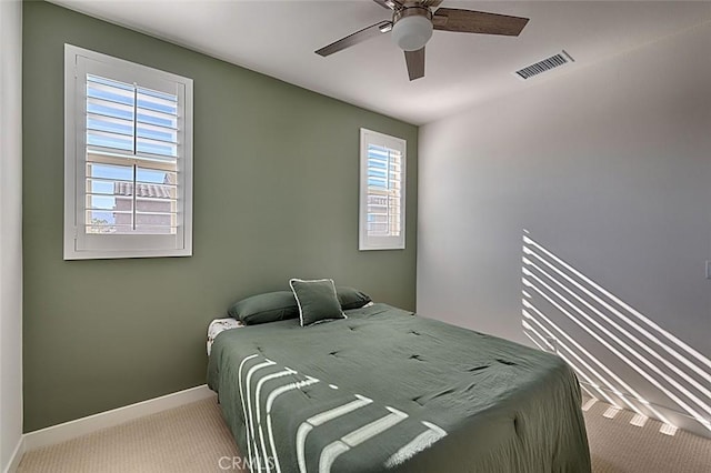 bedroom featuring ceiling fan, carpet floors, and multiple windows