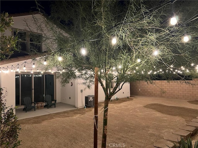 back house at night featuring a patio area