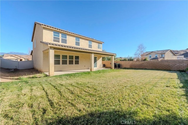 rear view of house with a patio area and a lawn