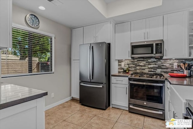 kitchen with backsplash, stainless steel appliances, and white cabinetry