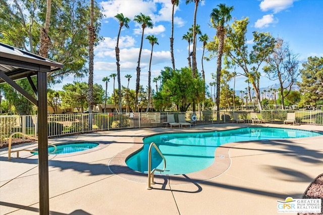 view of swimming pool with a hot tub and a patio area