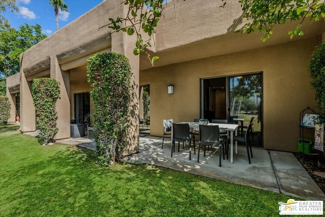 back of property featuring a patio area and a lawn