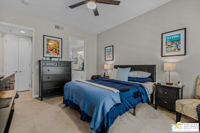 bedroom featuring ceiling fan, light colored carpet, and connected bathroom