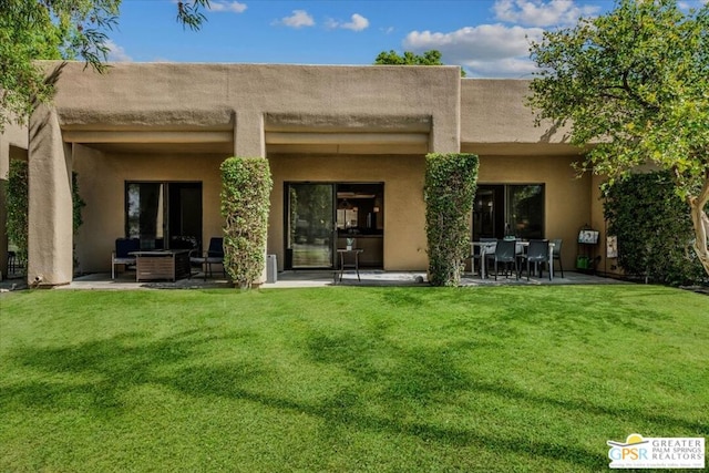 rear view of property featuring a patio area and a yard