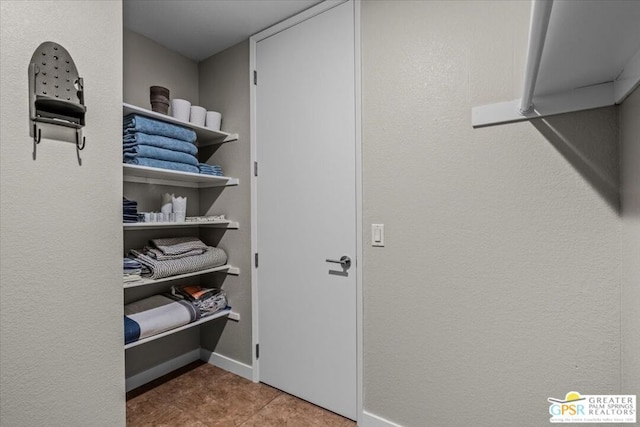 walk in closet with tile patterned flooring