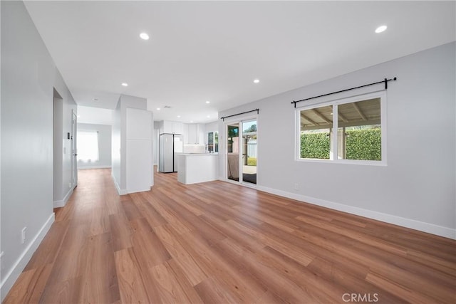 unfurnished living room with a wealth of natural light and light hardwood / wood-style flooring