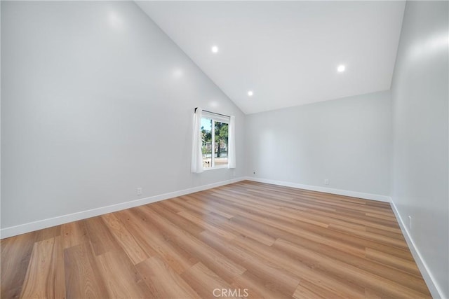 unfurnished room with high vaulted ceiling and light wood-type flooring