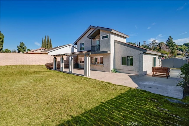 rear view of house with a lawn and a patio