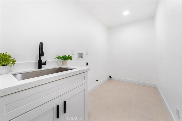 clothes washing area featuring cabinets, electric dryer hookup, sink, hookup for a washing machine, and light tile patterned floors