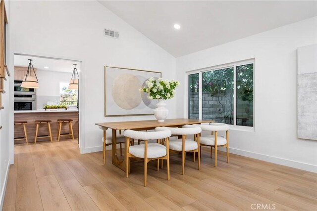 dining area featuring plenty of natural light, light hardwood / wood-style flooring, and a fireplace