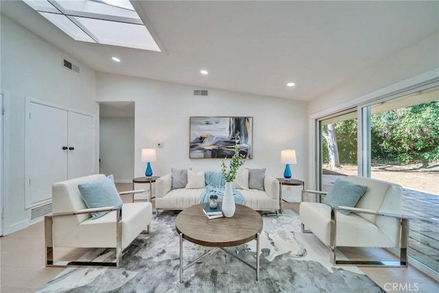 living room featuring lofted ceiling with skylight