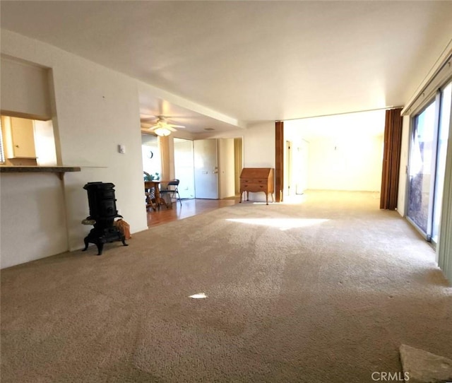 unfurnished living room featuring a ceiling fan and carpet