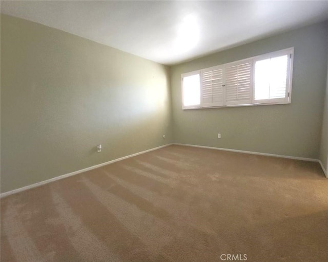 empty room with light colored carpet and baseboards