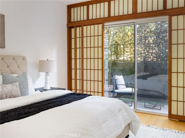 bedroom featuring access to exterior and light wood-type flooring