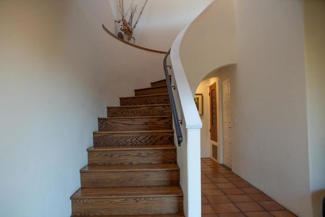 staircase featuring tile patterned flooring