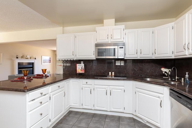 kitchen featuring sink, white cabinets, appliances with stainless steel finishes, and kitchen peninsula